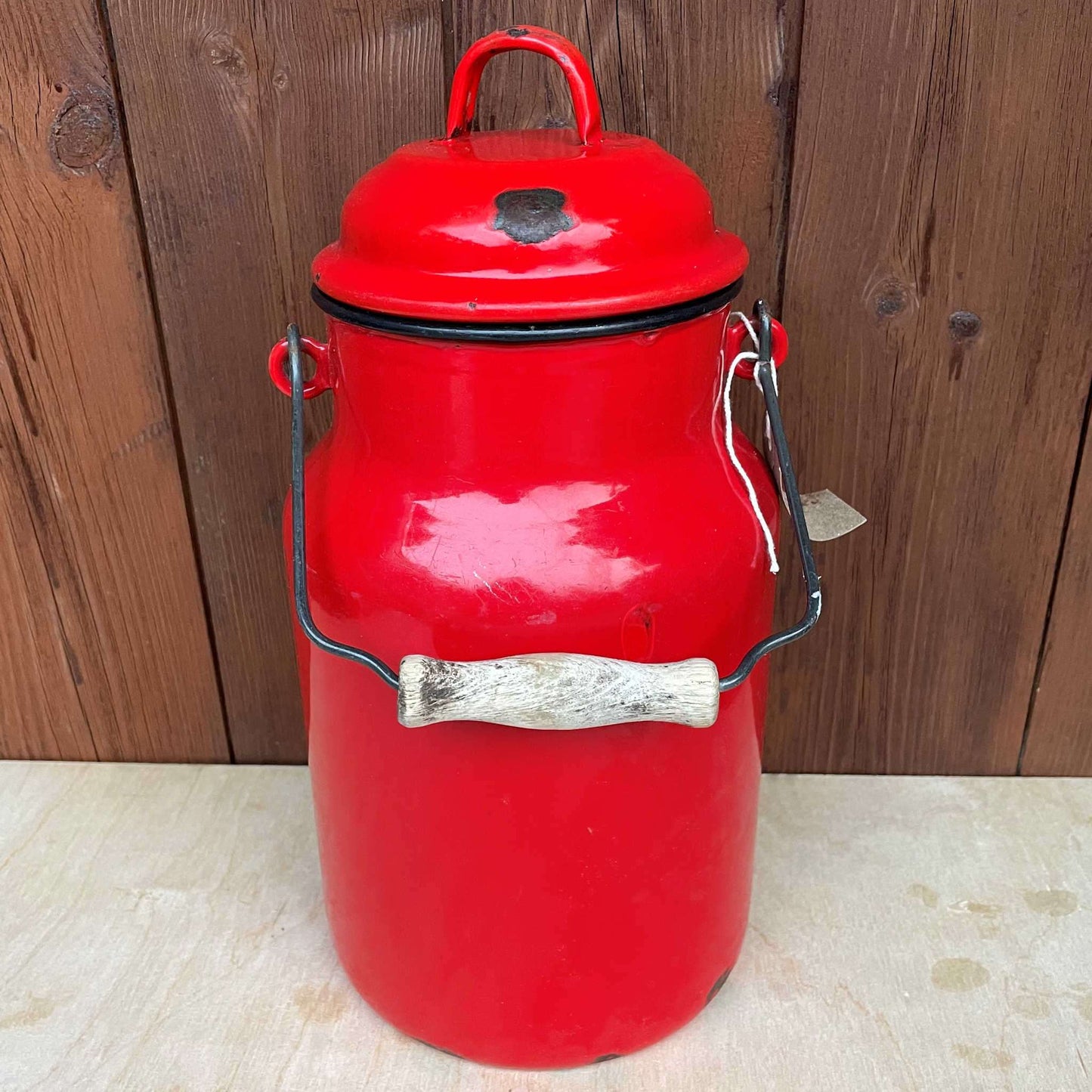 Red enamelled churn container with lid.