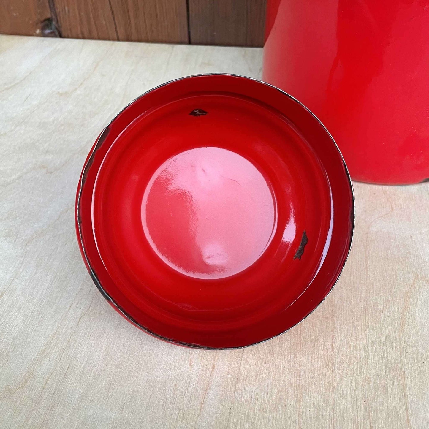 Red enamelled churn container with lid.