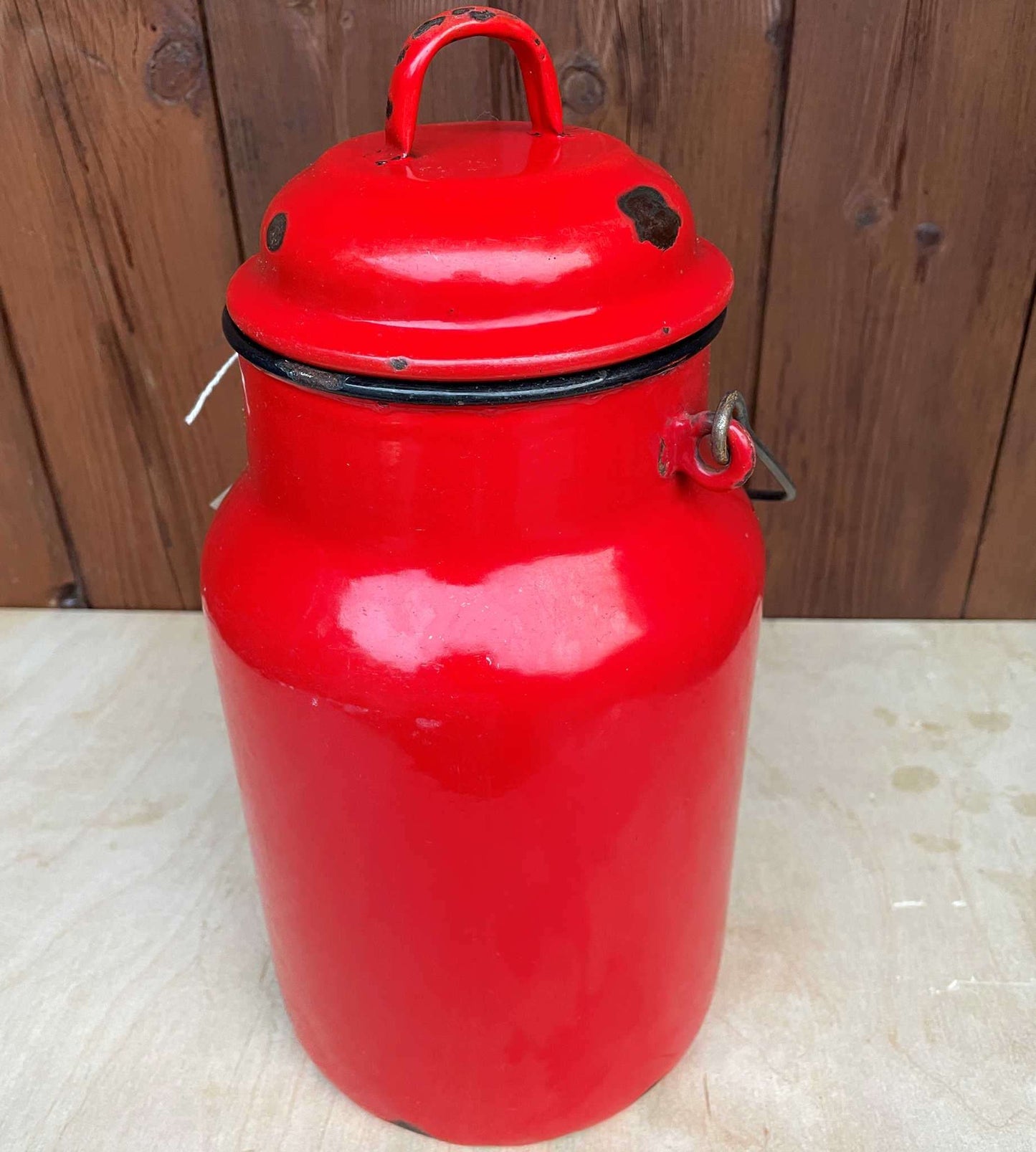 Red enamelled churn container with lid.
