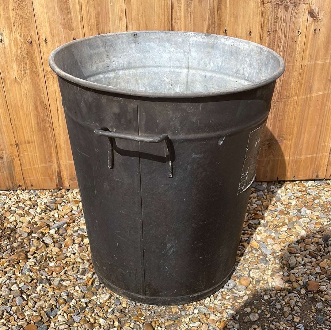 Rustic round galvanised bin garden planter with black aged paint.