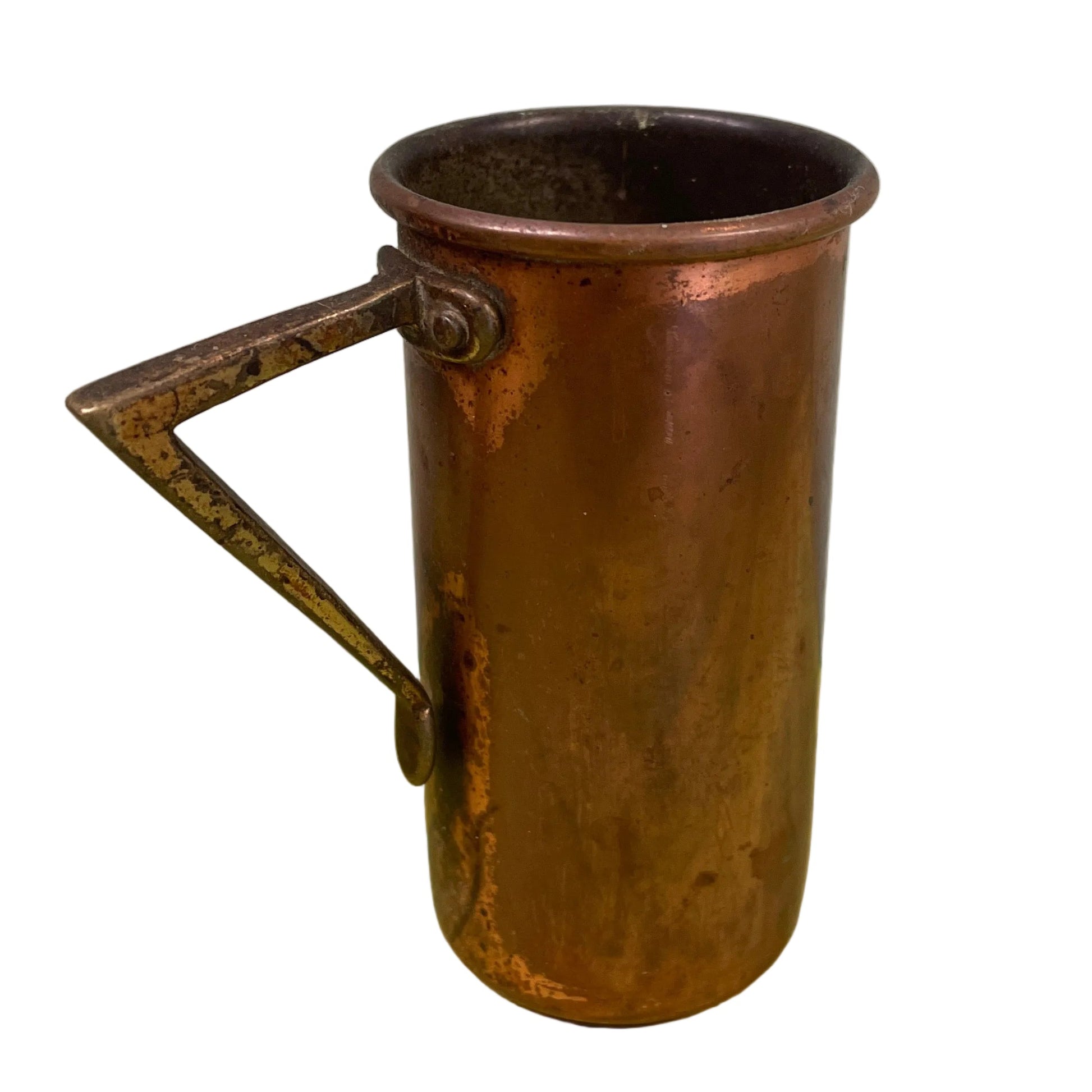 Vintage copper measuring cup against a white background.