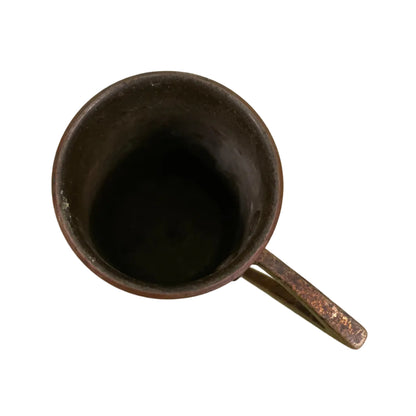 Vintage copper measuring cup against a white background.