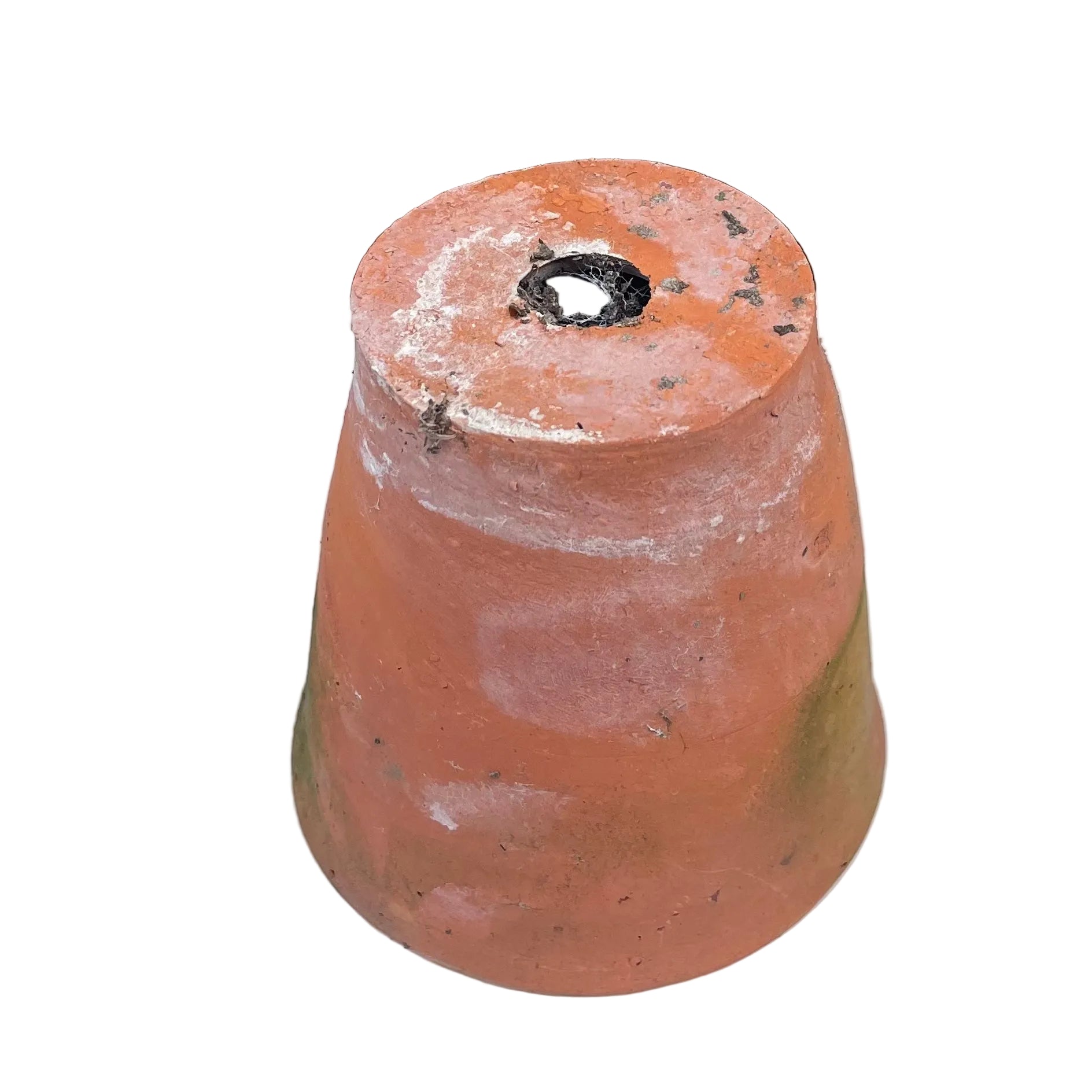 Terracotta pot with a hole on a white surface