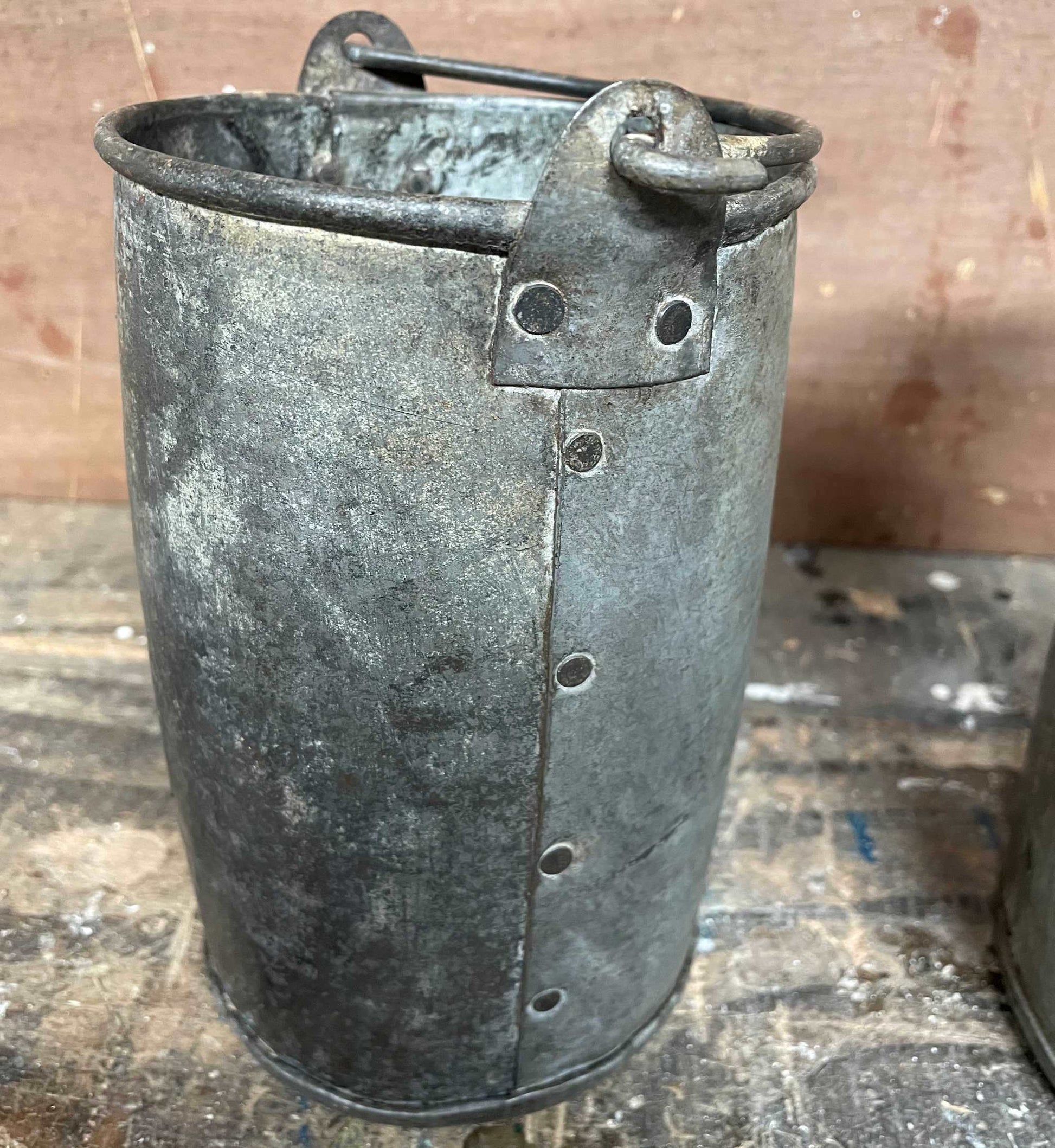 Metal planter bucket with handle.