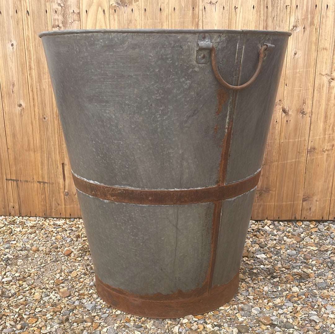 Large bucket type metal planter tree planting pot.