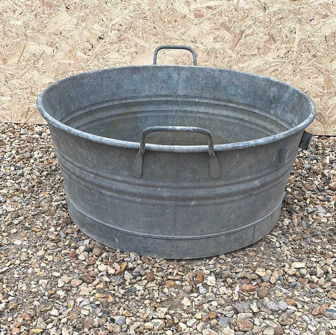 Round shallow galvanised straight sided tub planter with two handles.