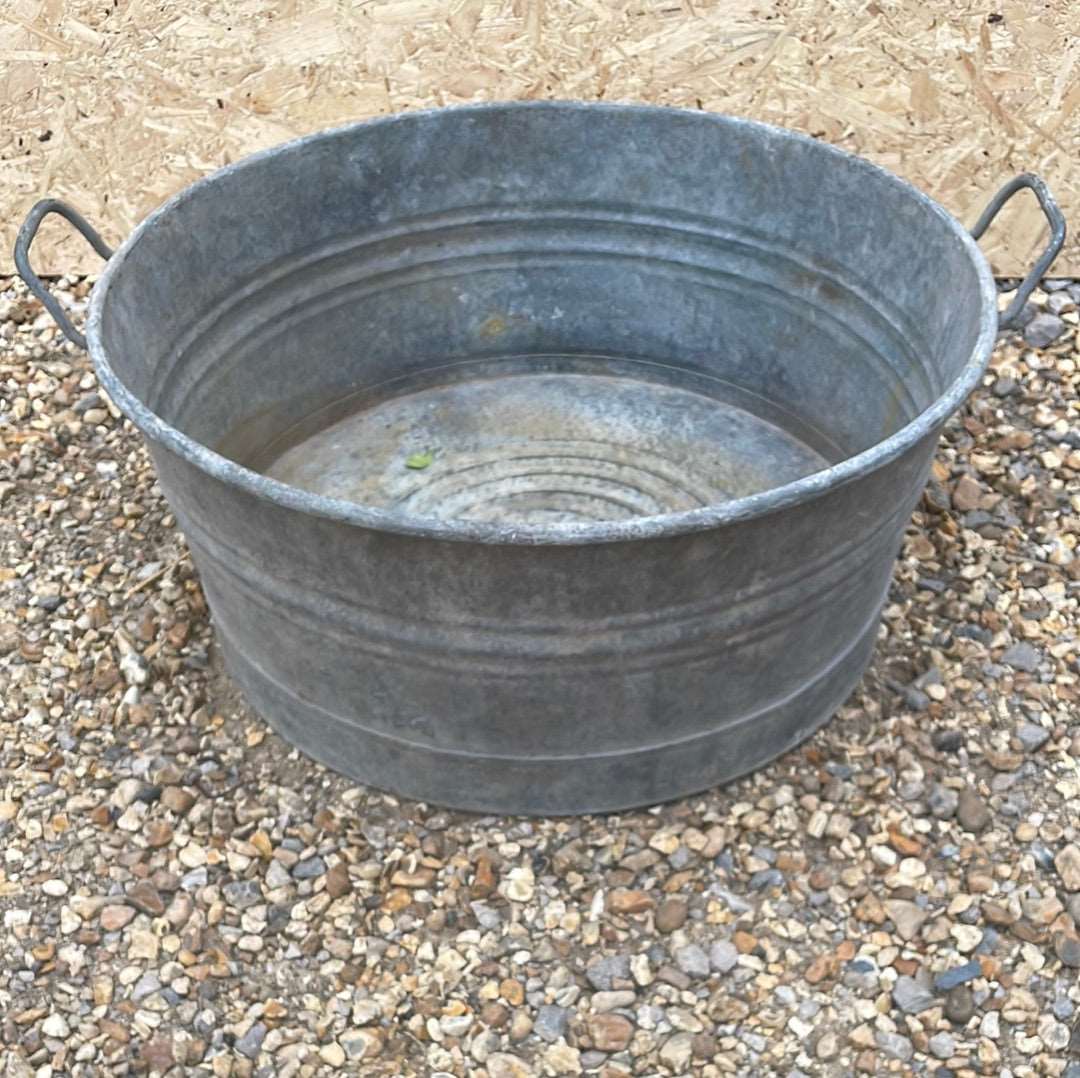 Round shallow galvanised straight sided tub planter with two handles.