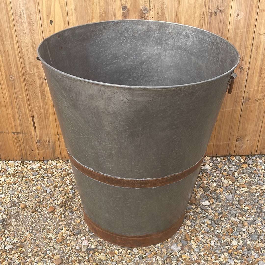Large bucket type metal planter tree planting pot.